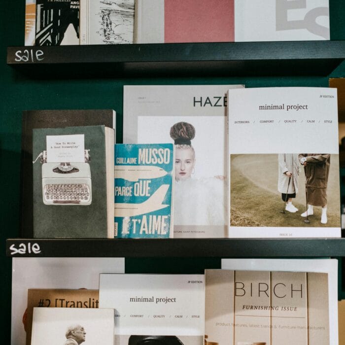 A bookshelf displaying an assortment of modern magazines and books in a stylish indoor setting.